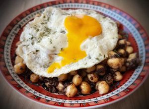 Una foto de Garbanzos salteados con morcilla y huevo frito