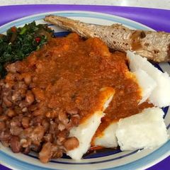 A picture of Yam and beans with vegetables stew and fish.