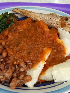 A picture of Yam and beans with vegetables stew and fish.
