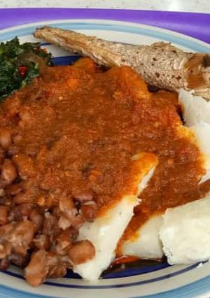 A picture of Yam and beans with vegetables stew and fish.