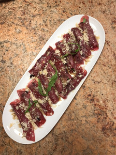 Una foto de Rollito de carpaccio con rúcula y ciruelas