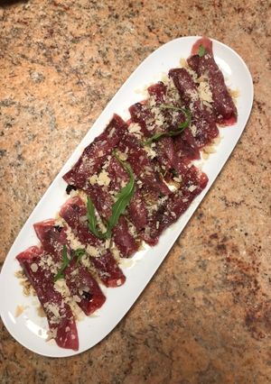 Una foto de Rollito de carpaccio con rúcula y ciruelas