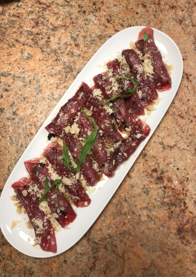 Una foto de Rollito de carpaccio con rúcula y ciruelas