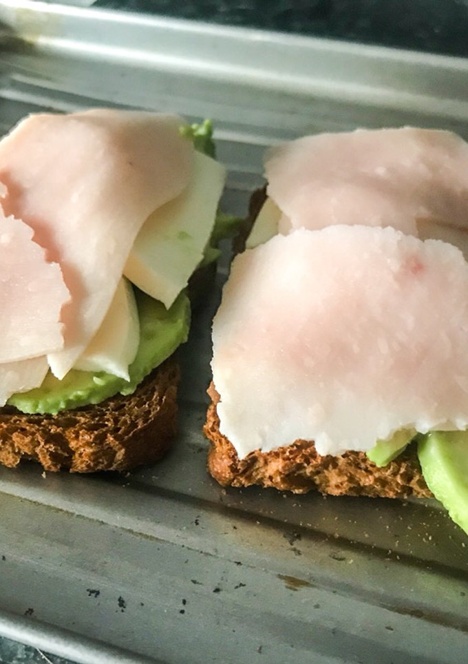 Una foto de Tostada de aguacate, tomate, queso y jamón