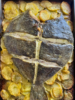 Una foto de Rodaballo con patatas panaderas al ajo