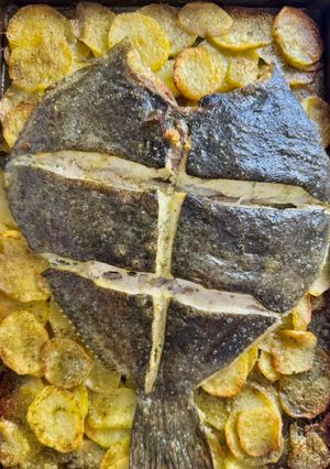 Una foto de Rodaballo con patatas panaderas al ajo