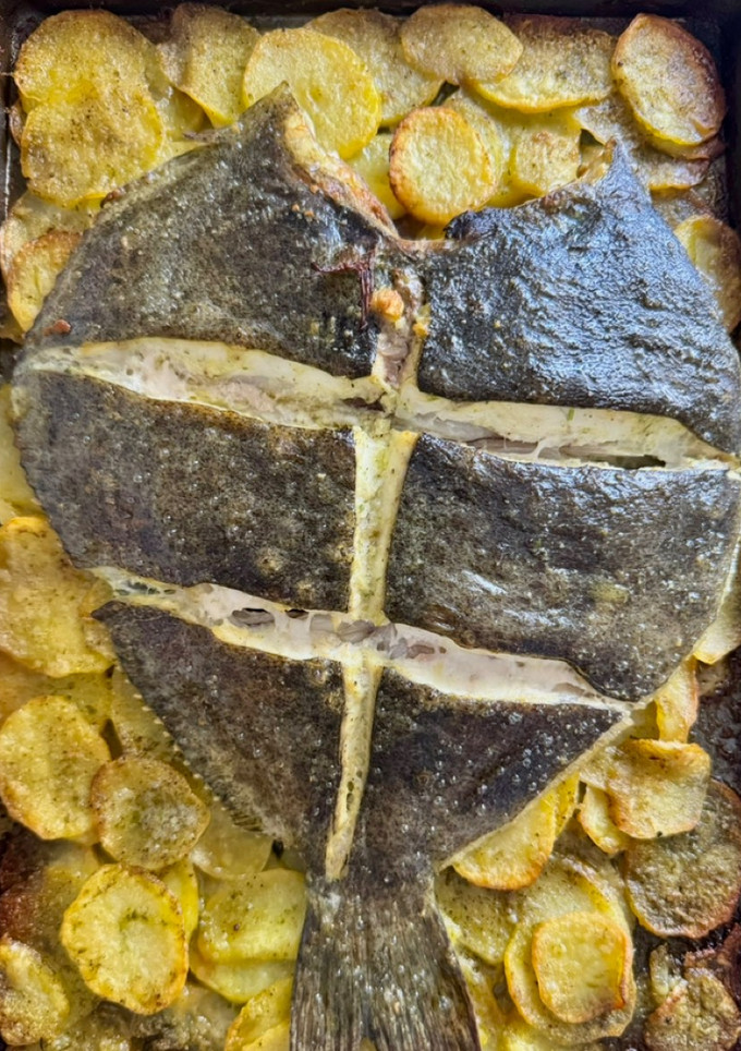 Una foto de Rodaballo con patatas panaderas al ajo