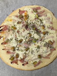 Una foto de Pizza de jamón cocido con mozzarella y pistacho