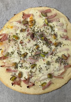 Una foto de Pizza de jamón cocido con mozzarella y pistacho