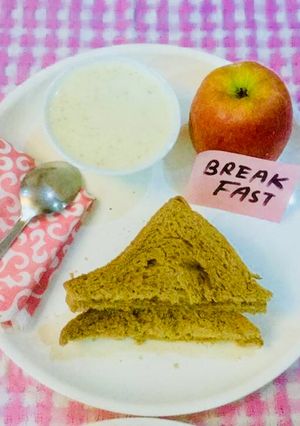 A picture of #Wheat bread-peanut butter toast,dry fruits porridge and an Apple.