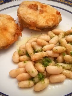 Una foto de Merluza Rebozada con alubias al ajillo