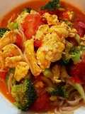 Scrambled eggs, broccoli and tomatoes over pasta