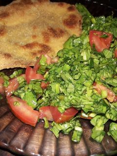 Una foto de Milanesa de pollo al horno con ensalada de rúcula y tomate
