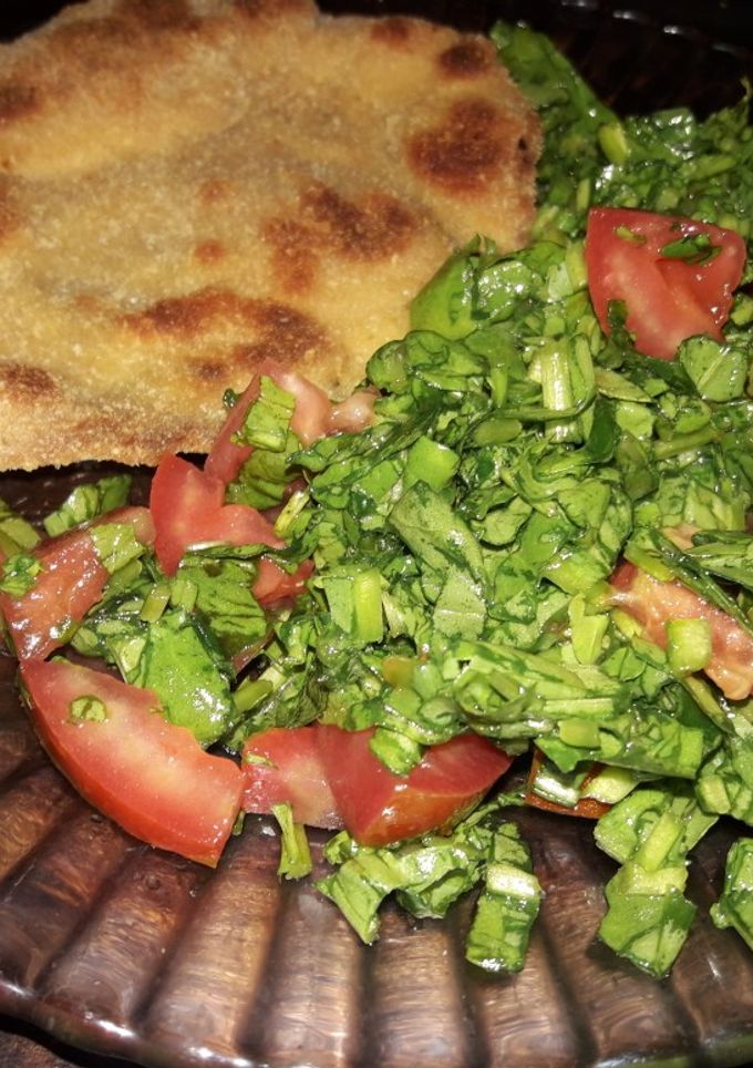 Una foto de Milanesa de pollo al horno con ensalada de rúcula y tomate