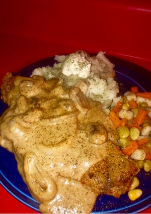 A picture of Cajun lemon pepper grilled strip steak w/ grilled onion 🍄 cream sauce and loaded 🥔 & seasoned veggie.