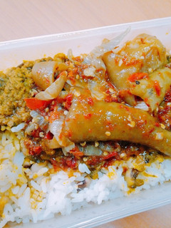 A picture of Peppered cow leg in banga sauce and white rice.