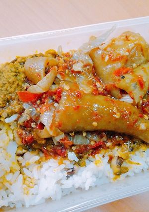 A picture of Peppered cow leg in banga sauce and white rice.