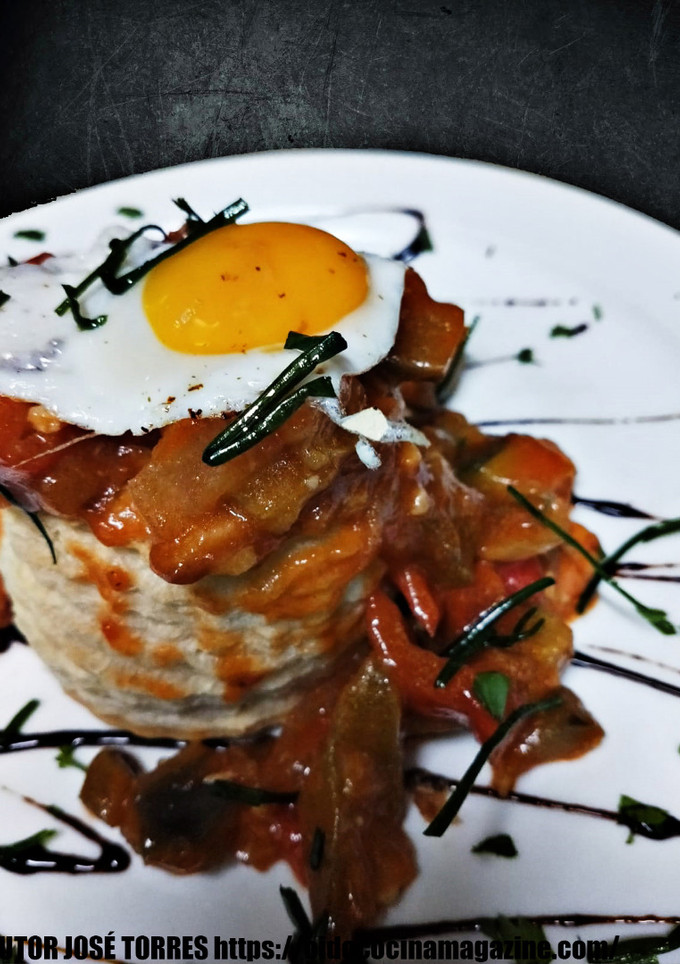 Una foto de Pisto de langostinos y cangrejo sobre hojaldre con huevo de codorniz