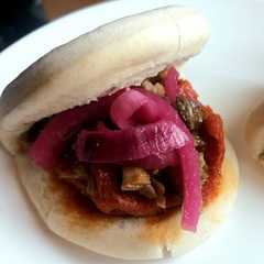 Una foto de Pan bao relleno de sobrasada picante, carrillera guisada y cebolla morada encurtida