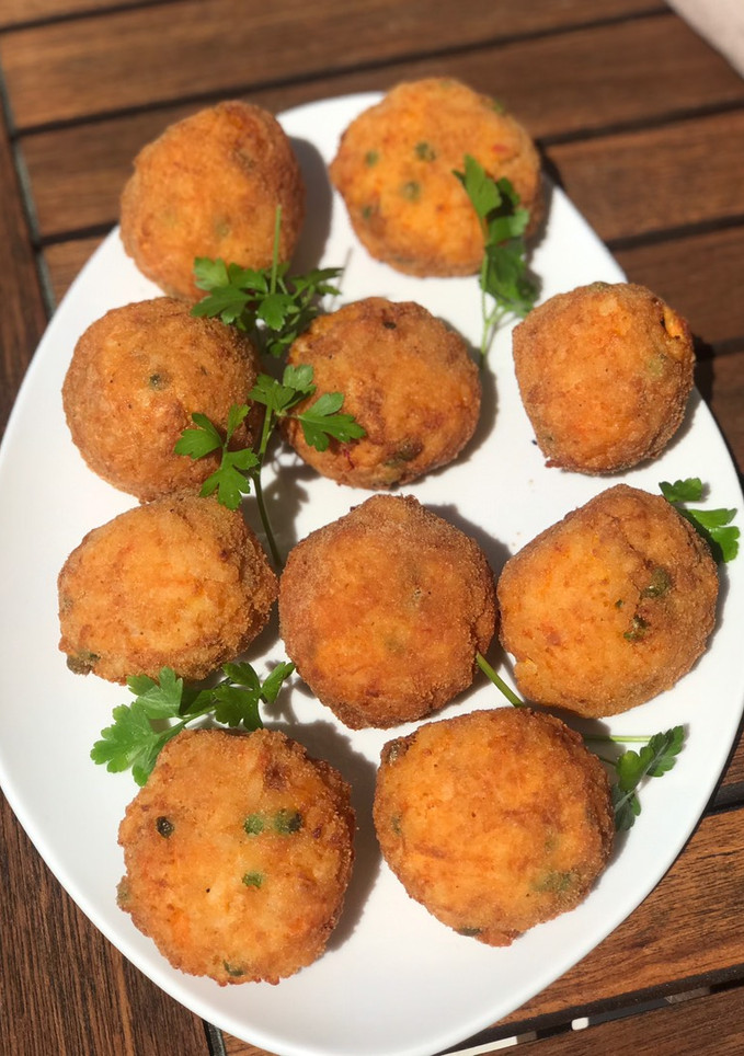 Una foto de Arancini croquetas con sabor a Sicilia y se caracterizan por un color anaranjado