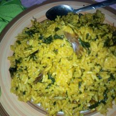 A picture of Local jollof rice garnished with vegetable.