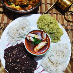 A picture of Colourful Stringhoppers with Crab stew.