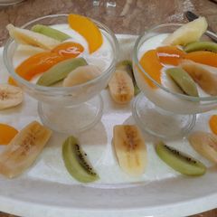 A picture of Curd with fruits and honey.