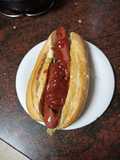 Perrito caliente isleño (salteado de cebolla y pimiento) y ketchup