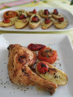 Una foto de Pollo con patatas, tomates y pimiento al ajo y perejil