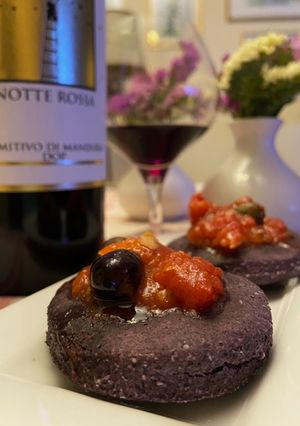 Foto di Pizzette di riso nero con baccalà e olive taggiasche