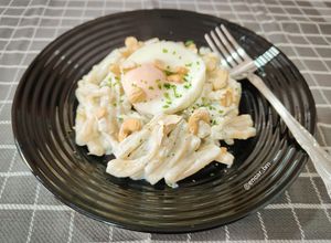 Una foto de Casarecce con salsa de ricota y albahaca, huevo poché y anacardos