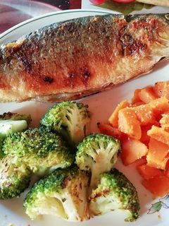 Una foto de Lubina acompañada de brócoli y calabaza a la plancha