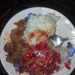 A picture of Rice fried meat and kachumbari.