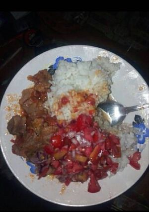 A picture of Rice fried meat and kachumbari.