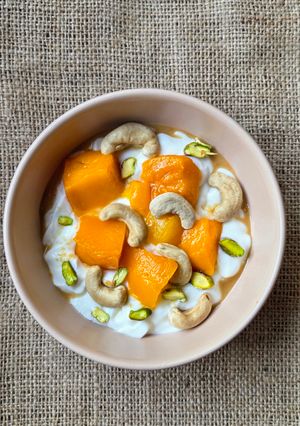 Una foto de Smoothie bowl de yogur casero enriquecido 🥭 yogur con mango, castañas de cajú, pistachos y más