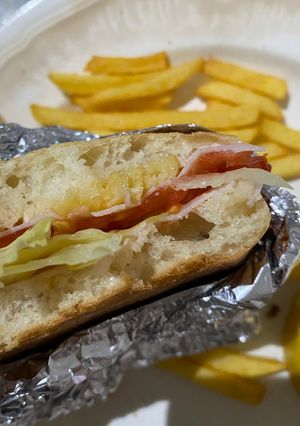 Una foto de Sándwich de pavo, lechuga, tomate, mayonesa, limón y patatas fritas