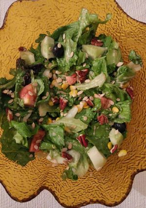 A picture of Green leafy salad with nuts and seeds.