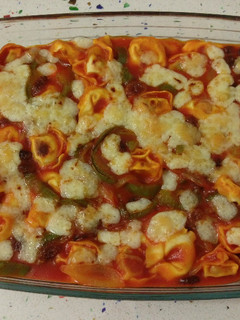 Una foto de Cappellettis de jamón con pasas, salsa de tomate y gratinados con queso viejo