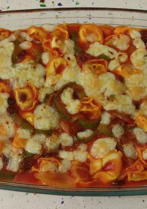 Una foto de Cappellettis de jamón con pasas, salsa de tomate y gratinados con queso viejo