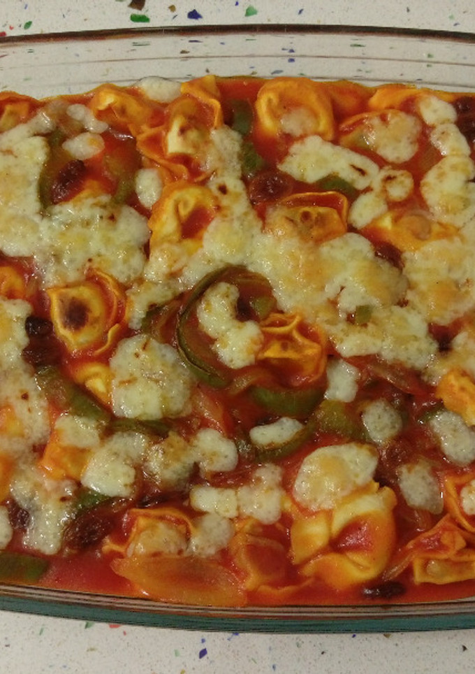 Una foto de Cappellettis de jamón con pasas, salsa de tomate y gratinados con queso viejo