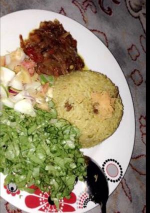 A picture of Fried rice with salad and sauce.