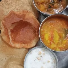 A picture of Puri with sabji and raita.