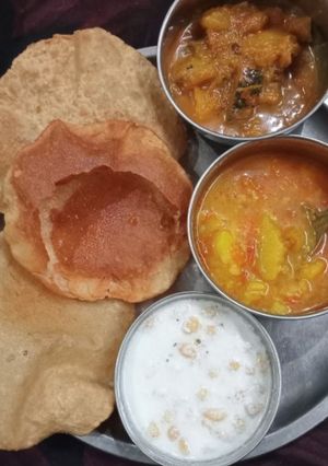 A picture of Puri with sabji and raita.