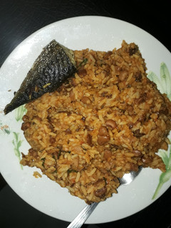 A picture of Rice and beans porriage with fried fish.