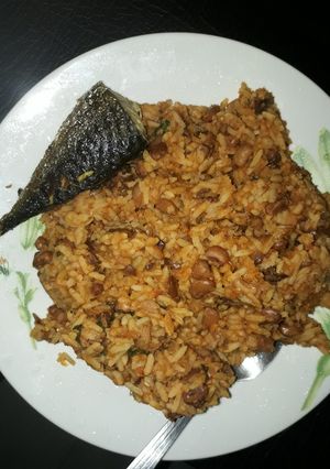 A picture of Rice and beans porriage with fried fish.