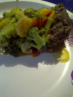 A picture of Meatloaf Pizza, on the stove top.