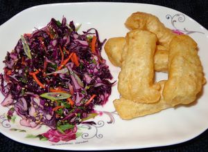 Una foto de Bacalao fresco, frito con batido de cerveza. Ensalada de repollo morado, tailandés