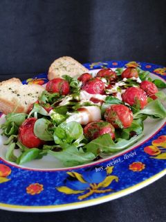 Una foto de Ensalada de rúcula, cherrys asados y burrata