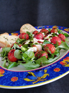 Una foto de Ensalada de rúcula, cherrys asados y burrata