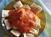 Una foto de ravioles de carne con salsa boloñesa